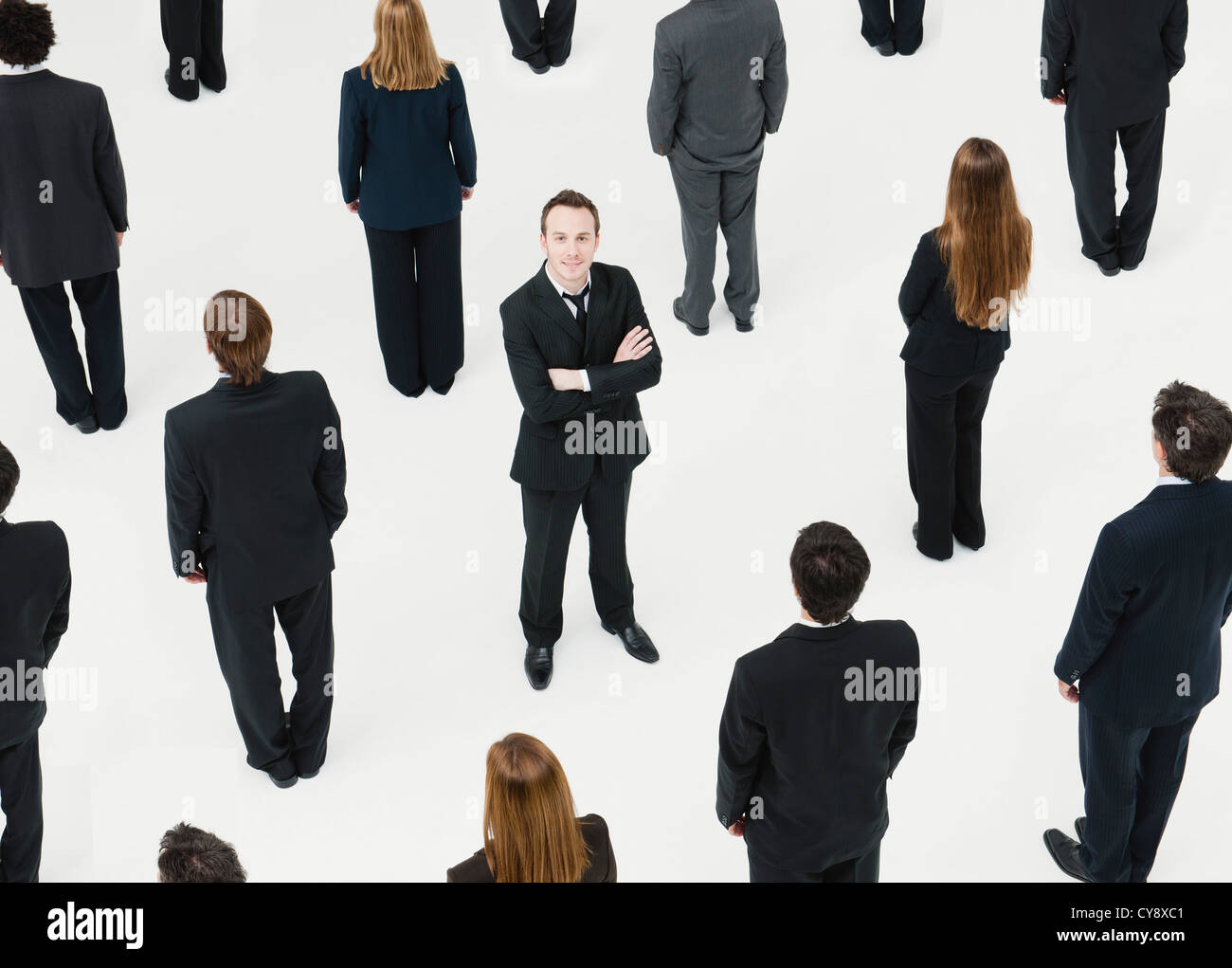 Geschäftsmann mit Arme gekreuzt stehen inmitten von anonym gekleidete Geschäftsleute Stockfoto