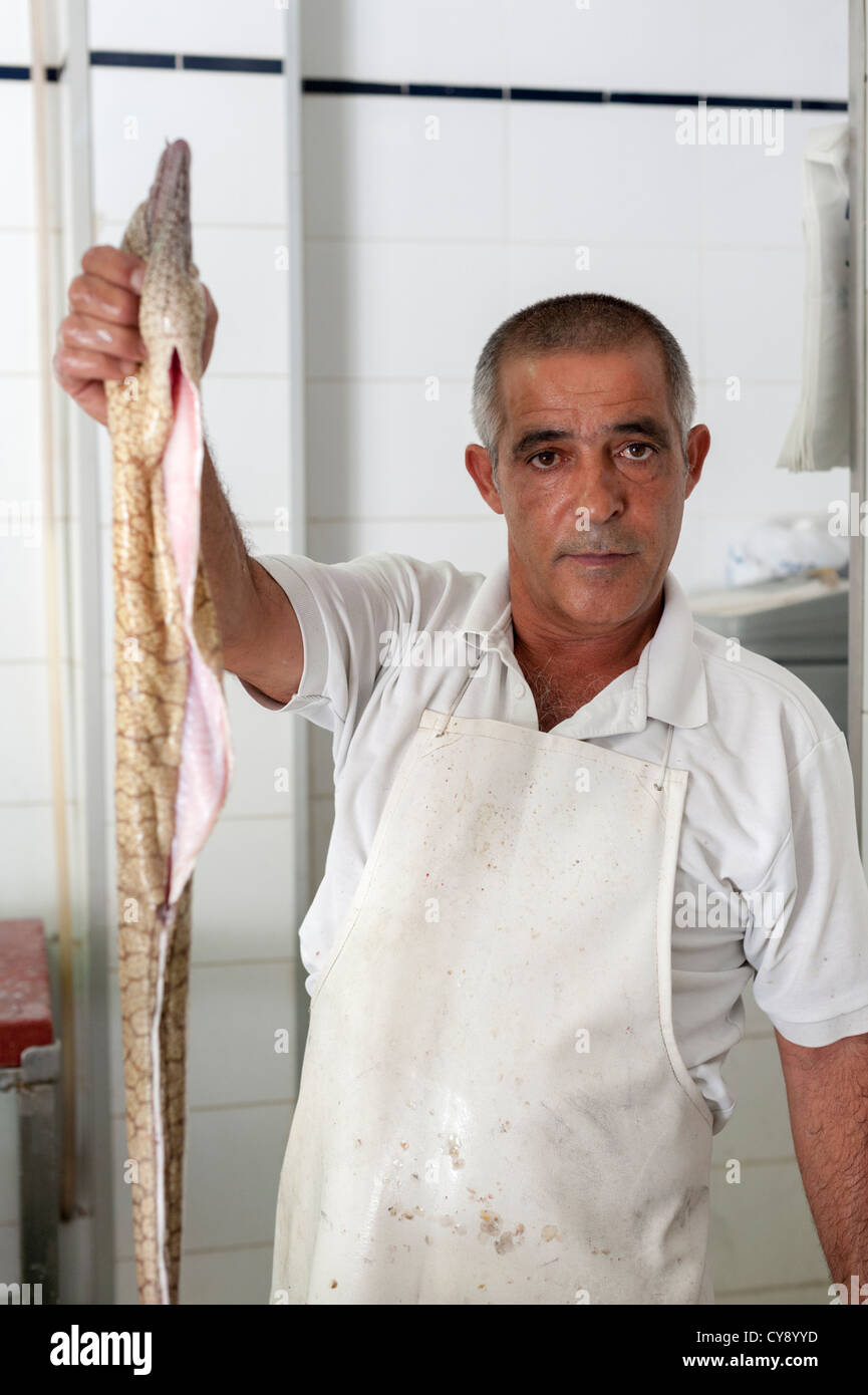 Ein Fischhändler hält eine Muräne am Puerto de Mogan Gran Canaria Kanaren Spanien Stockfoto