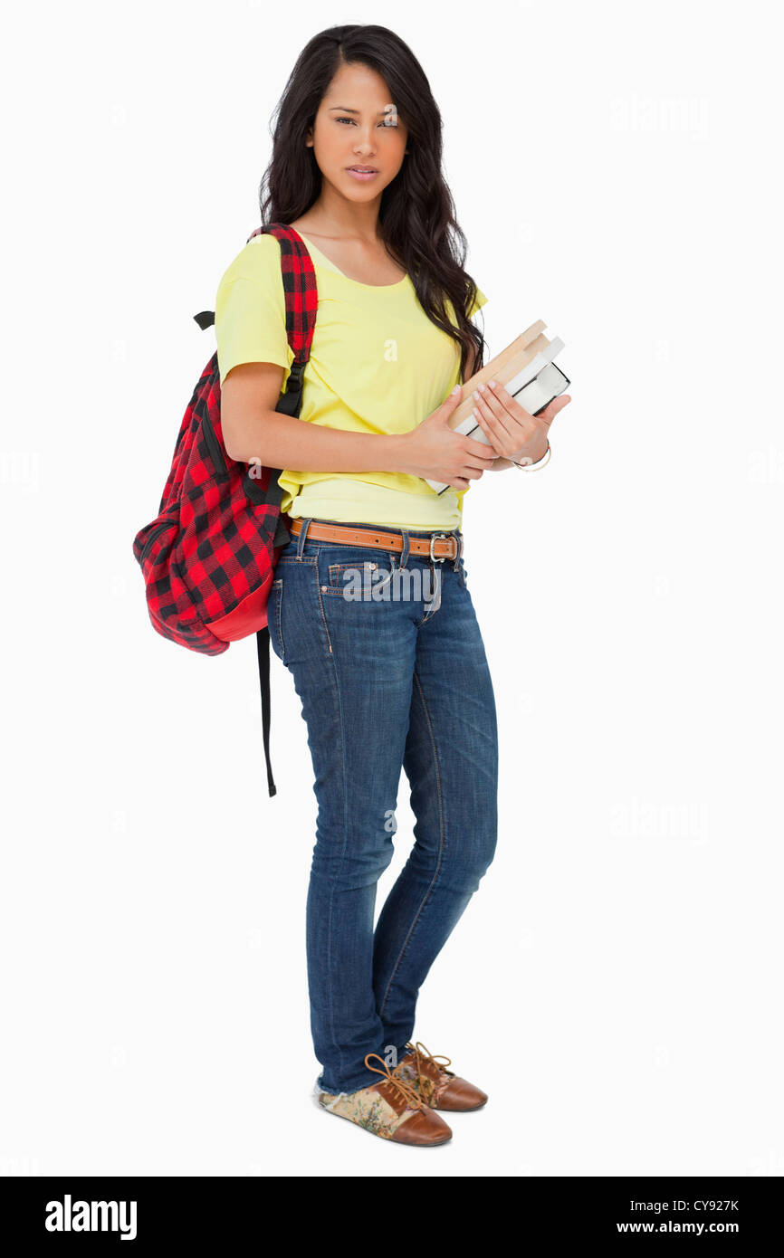 Schöne Studentin mit Rucksack hält Lehrbücher Stockfoto