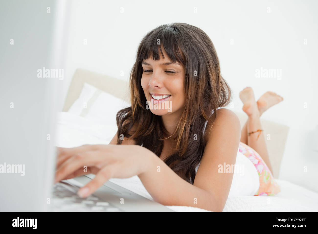 Lächelnde Frau, die im Chat auf einem laptop Stockfoto