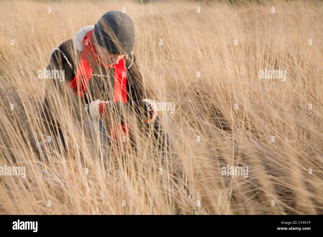 Caucasian Female lange Gras sitzen. Stockfoto