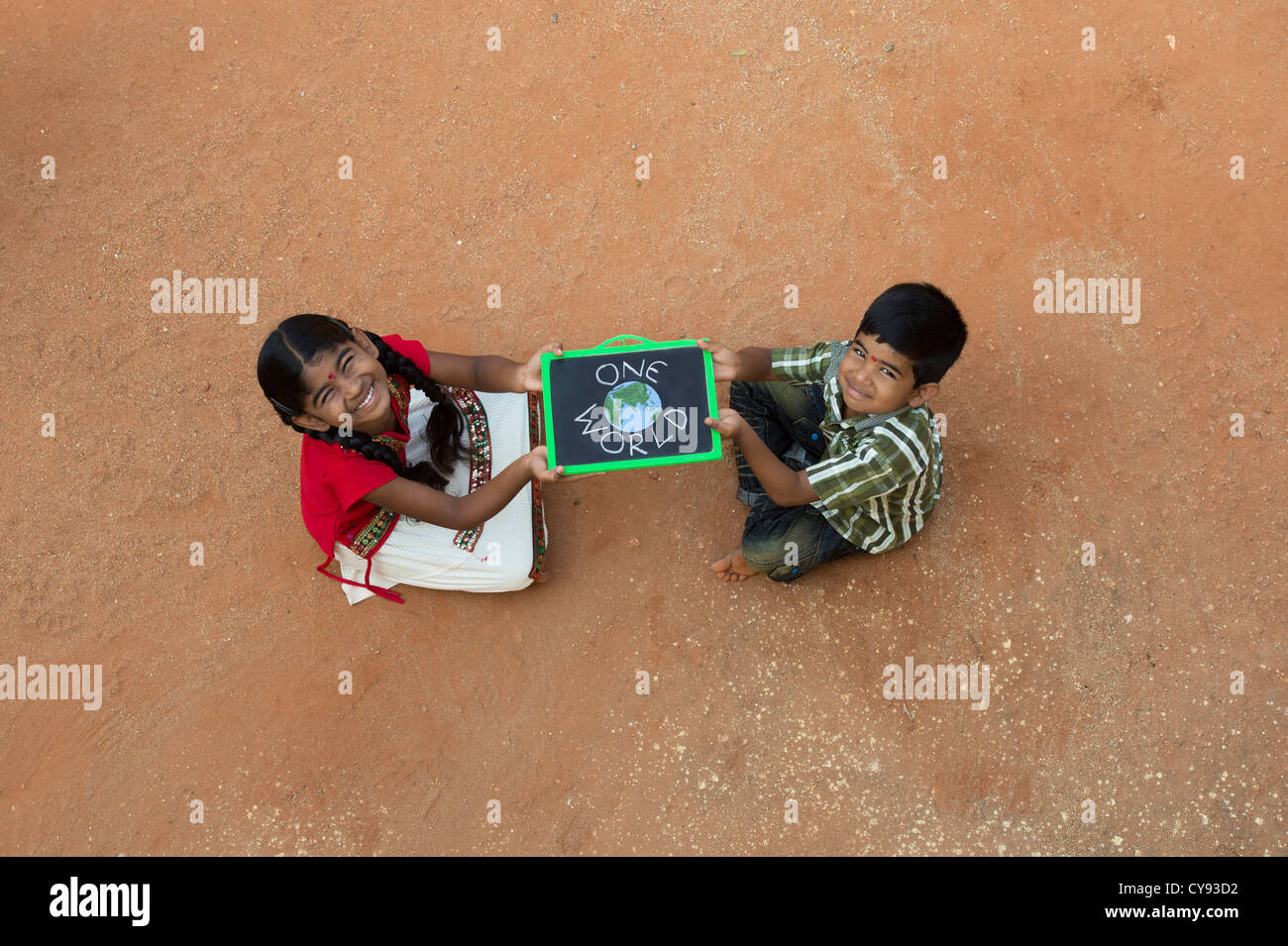 Indianerdorf Mädchen und Jungen mit ONE WORLD geschrieben auf einer Tafel in einem indischen Dorf. Andhra Pradesh, Indien Stockfoto
