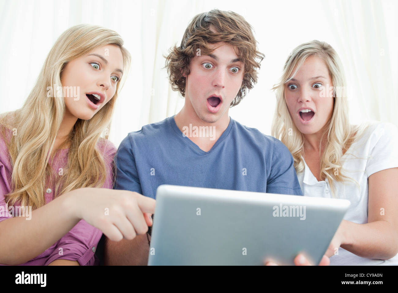 Drei schockiert Freunde Blick auf dem Bildschirm des Tablets Stockfoto