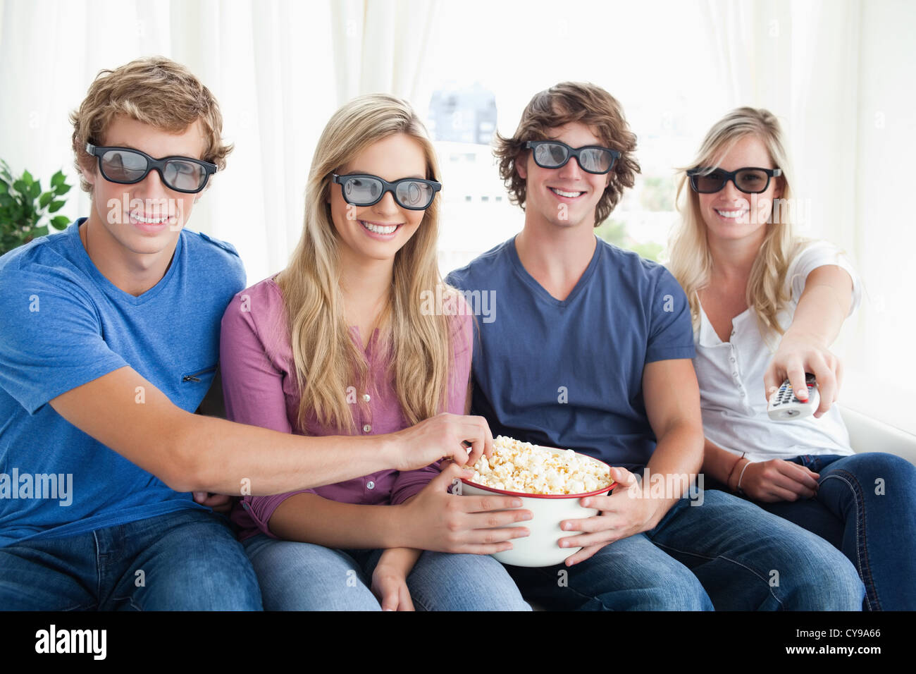 Freunde, Lächeln, als sie Popcorn Essen und einen 3d Film Stockfoto
