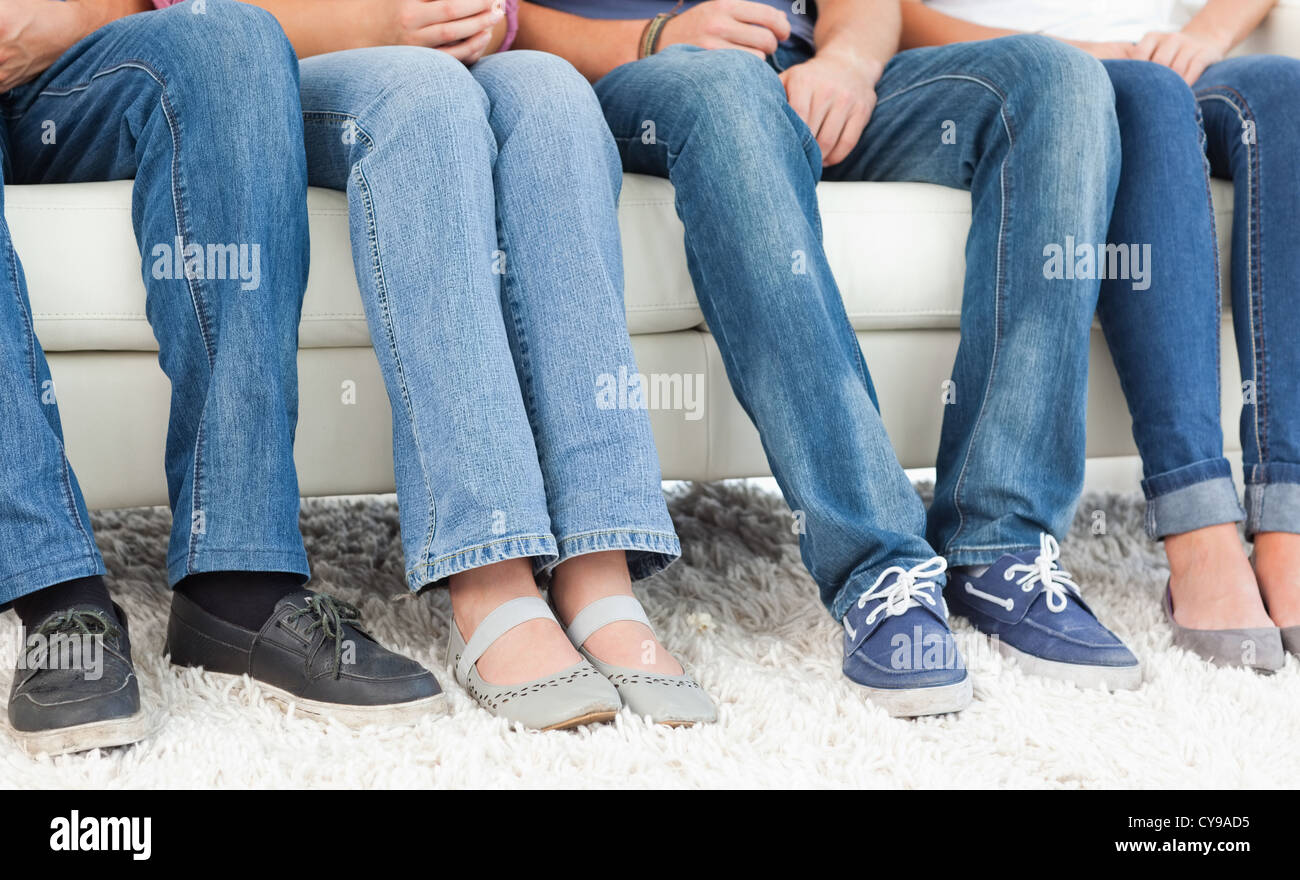 Vier Paar Füsse nebeneinander an der couch Stockfoto