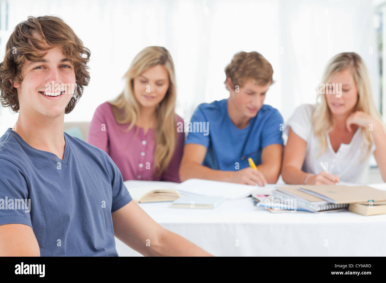 Nahaufnahme von ein lächelnder Mann sitzt vor seinen Freunden Stockfoto