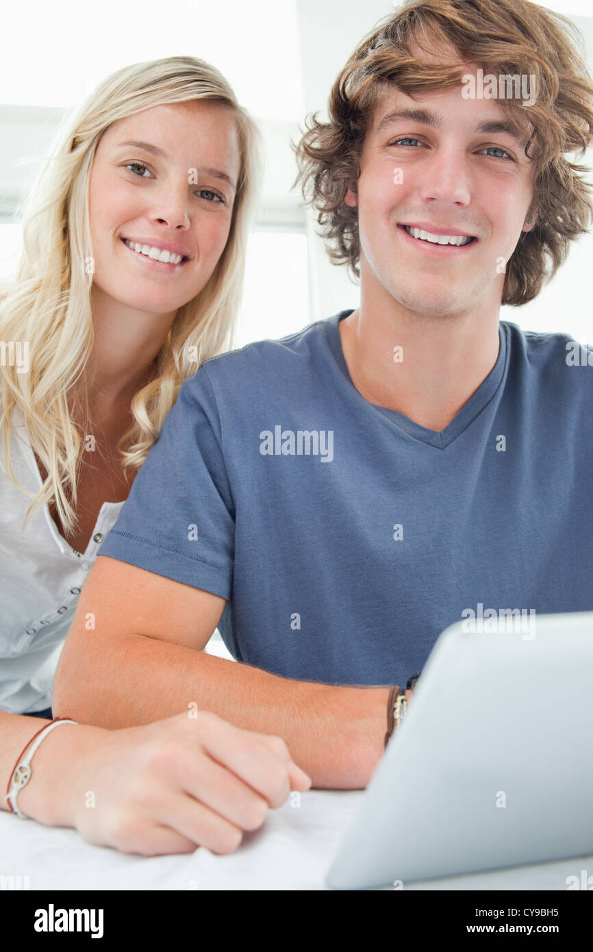 Lächelnde paar hält eine Tablette und schaut in die Kamera hautnah Stockfoto