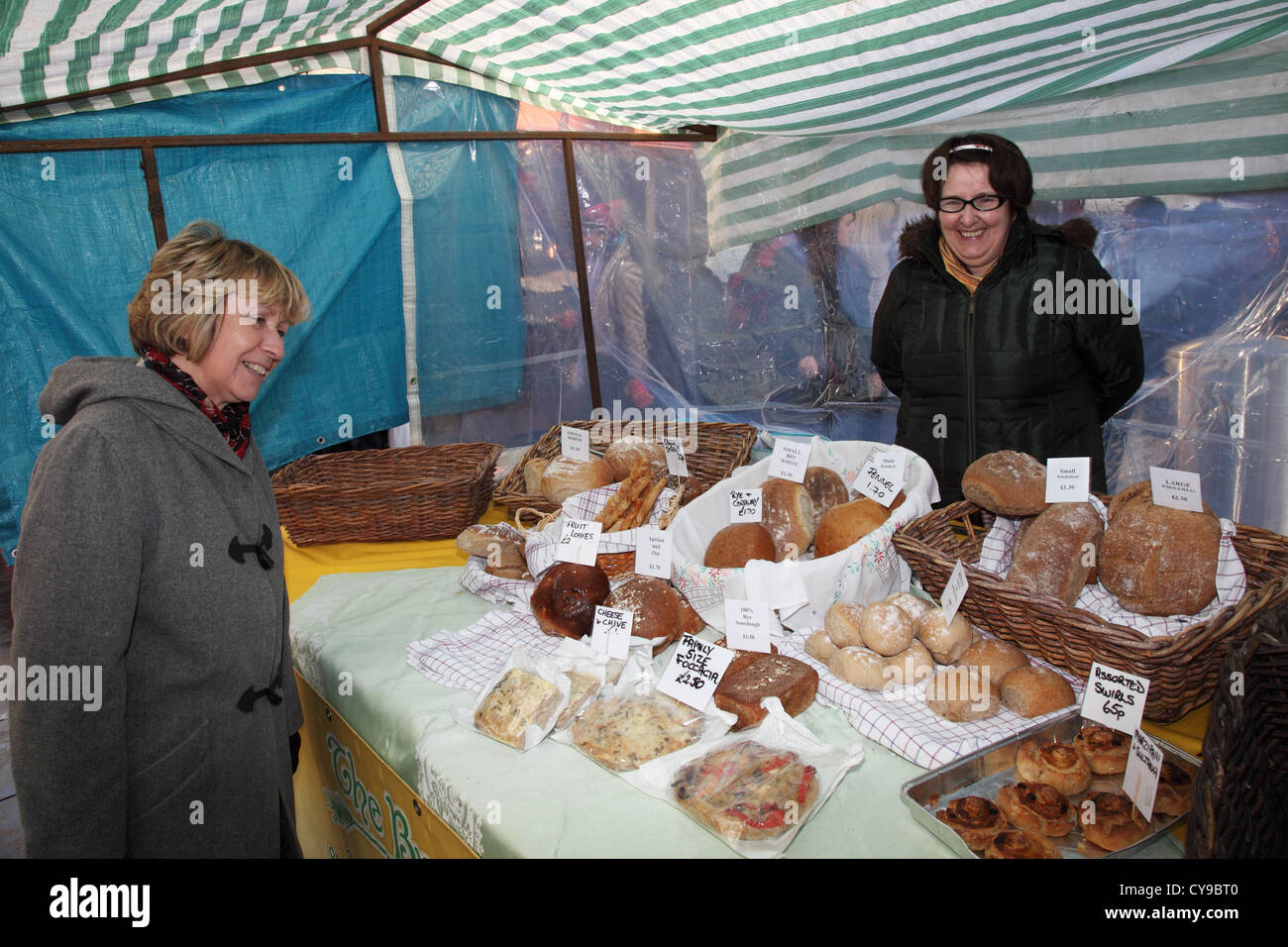 Lächelnde Frau Standinhaber und Kundin Handwerker Brot stall Durham City Food Festival, Nord-Ost-England, UK Stockfoto