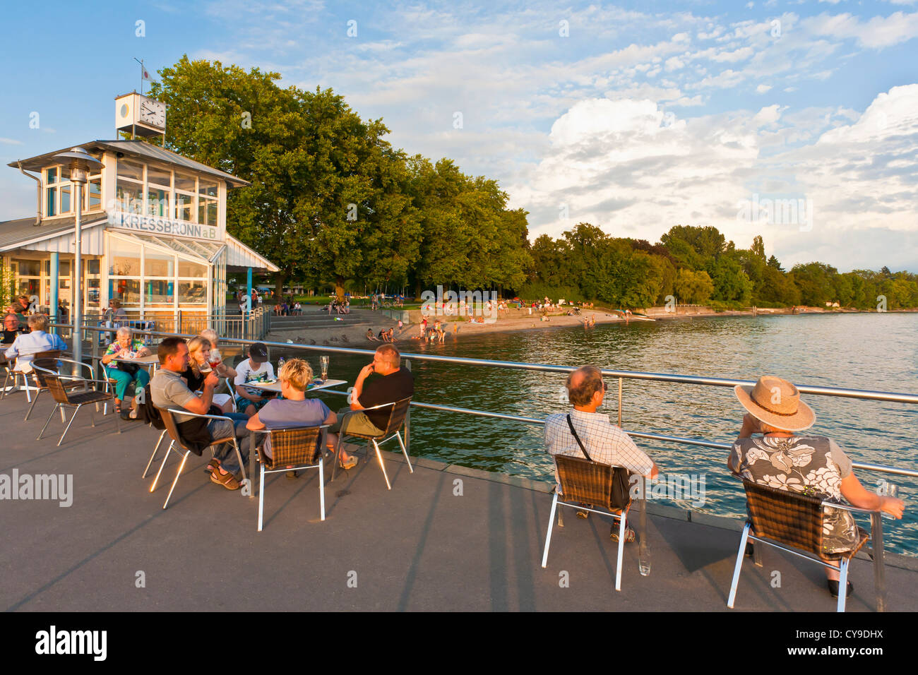 LEUTE SITZEN BEI SHIPPING PIER IN KRESSBRONN AM BODENSEE, BADEN-WÜRTTEMBERG, DEUTSCHLAND Stockfoto