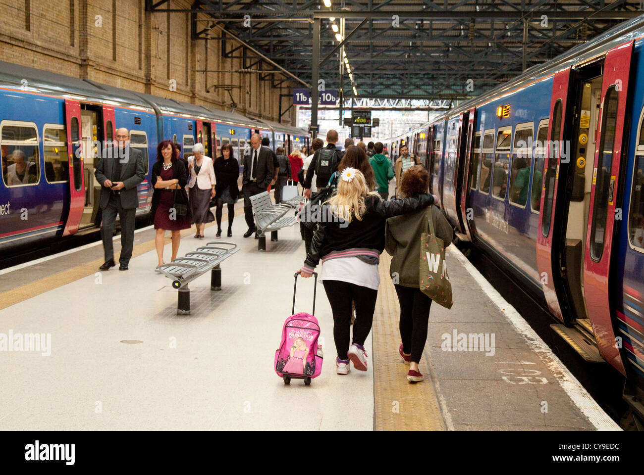 Fahrgäste im Eisenbahnverkehr fangen einen Zug, der Plattform, Kings Cross Bahnhof, London UK Stockfoto