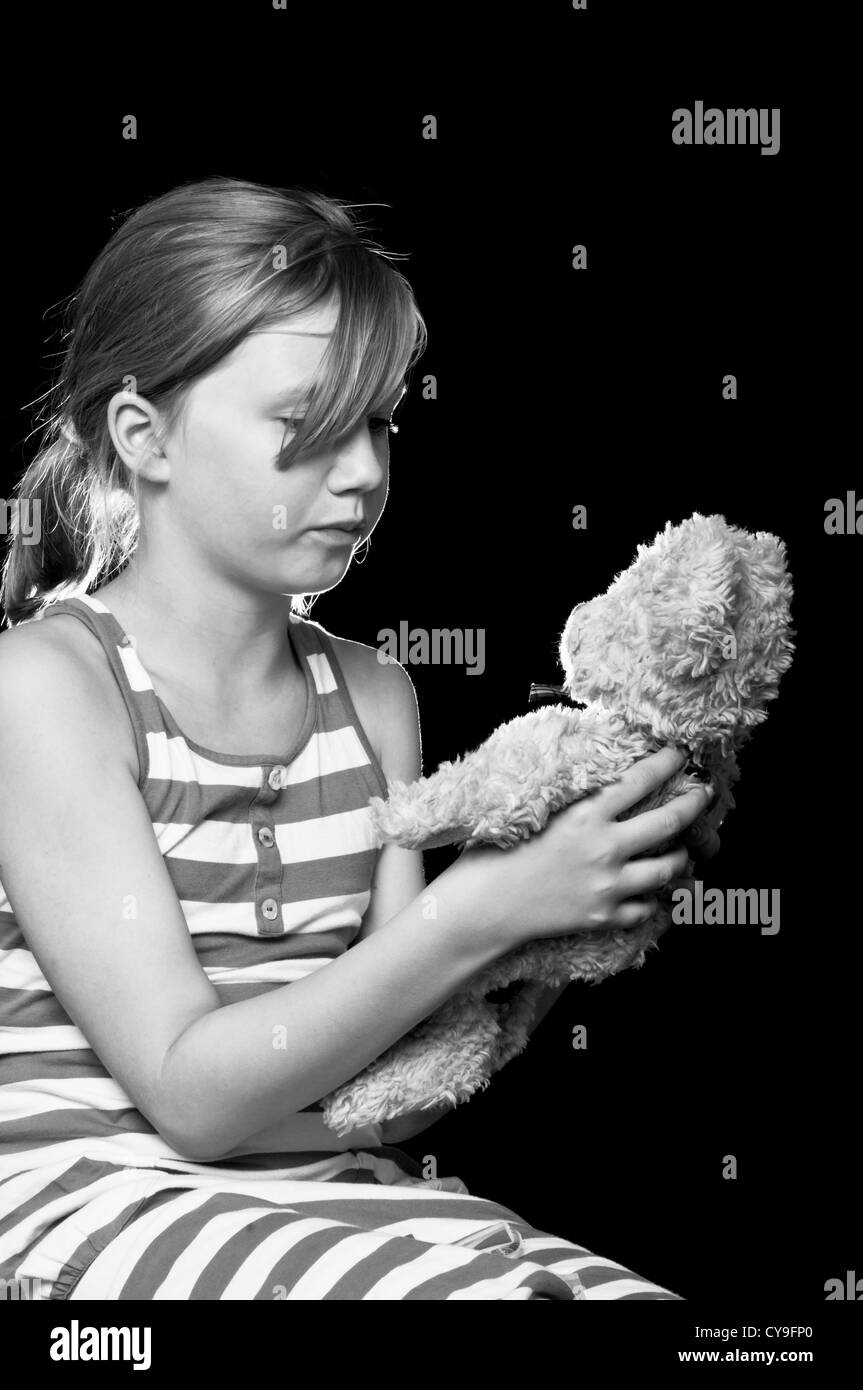 Trauriges Mädchen hält einen Teddybär Stockfoto