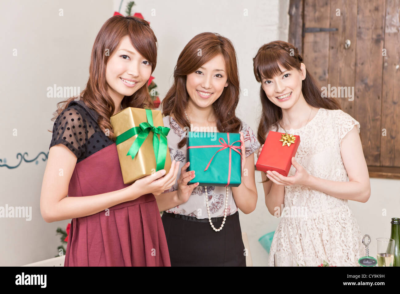 Drei junge Frauen halten Geschenkboxen Stockfoto