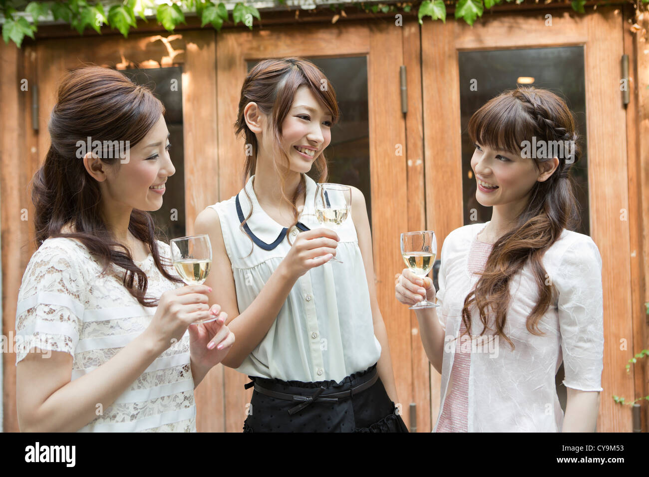 Drei junge Frauen Weingenuss auf Terrasse Stockfoto