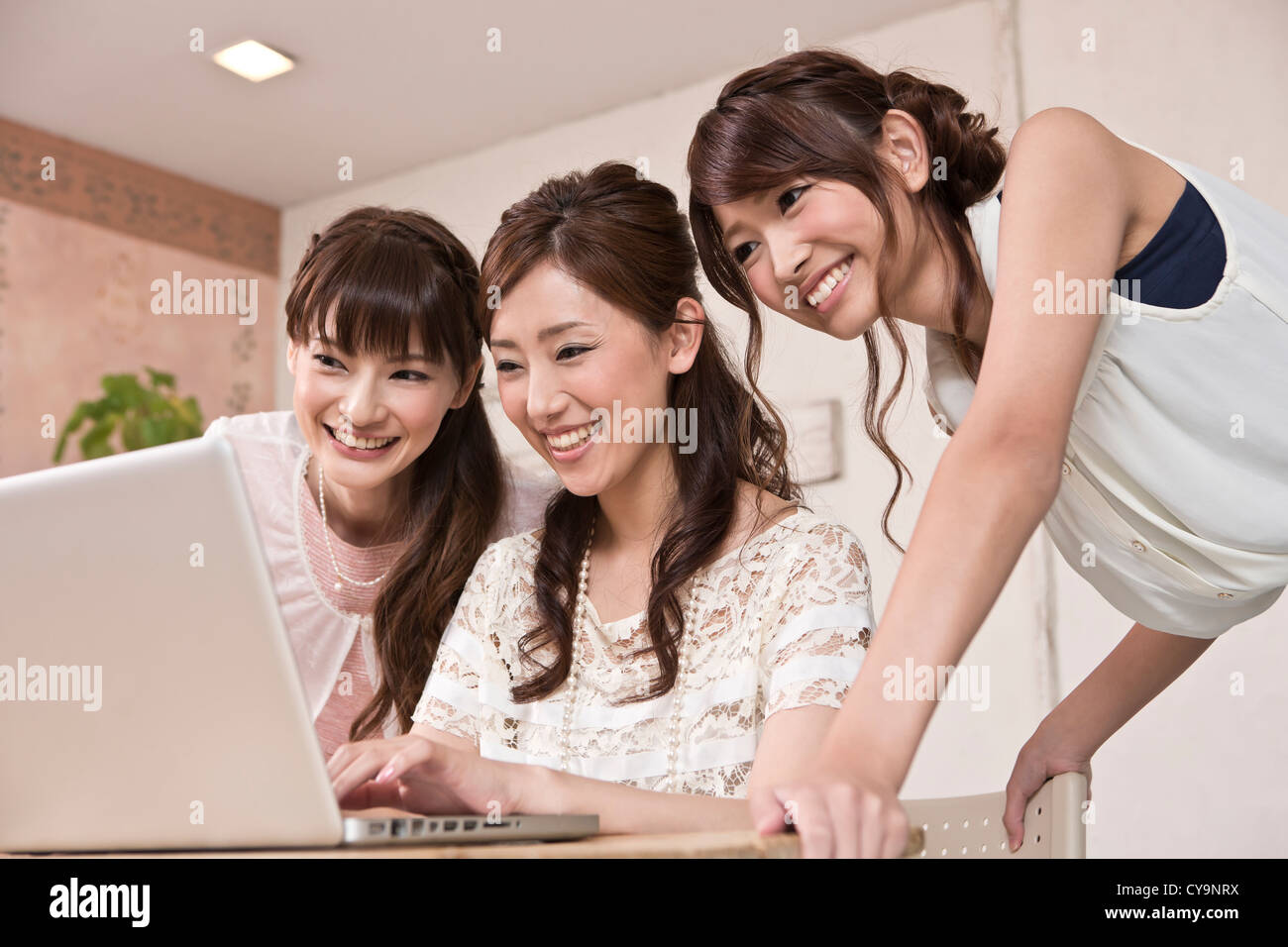 Drei junge Frau auf der Suche Laptop zusammen Stockfoto