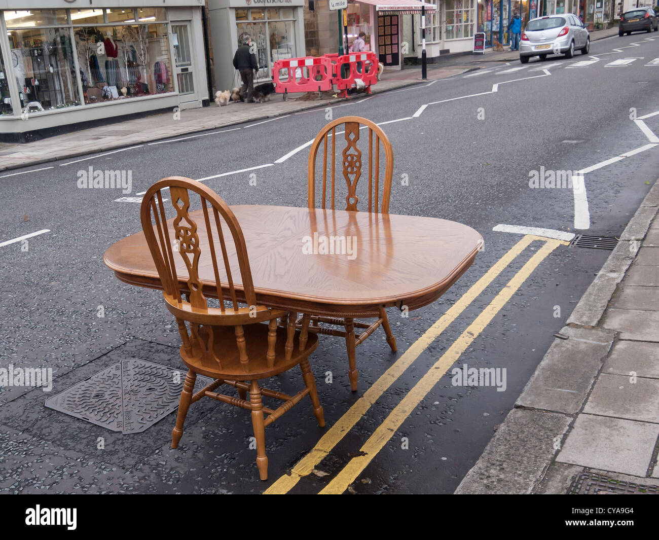 Ein Esstisch und Stühlen eingerichtet, in der Straße in einem Dorf High Street Stockfoto