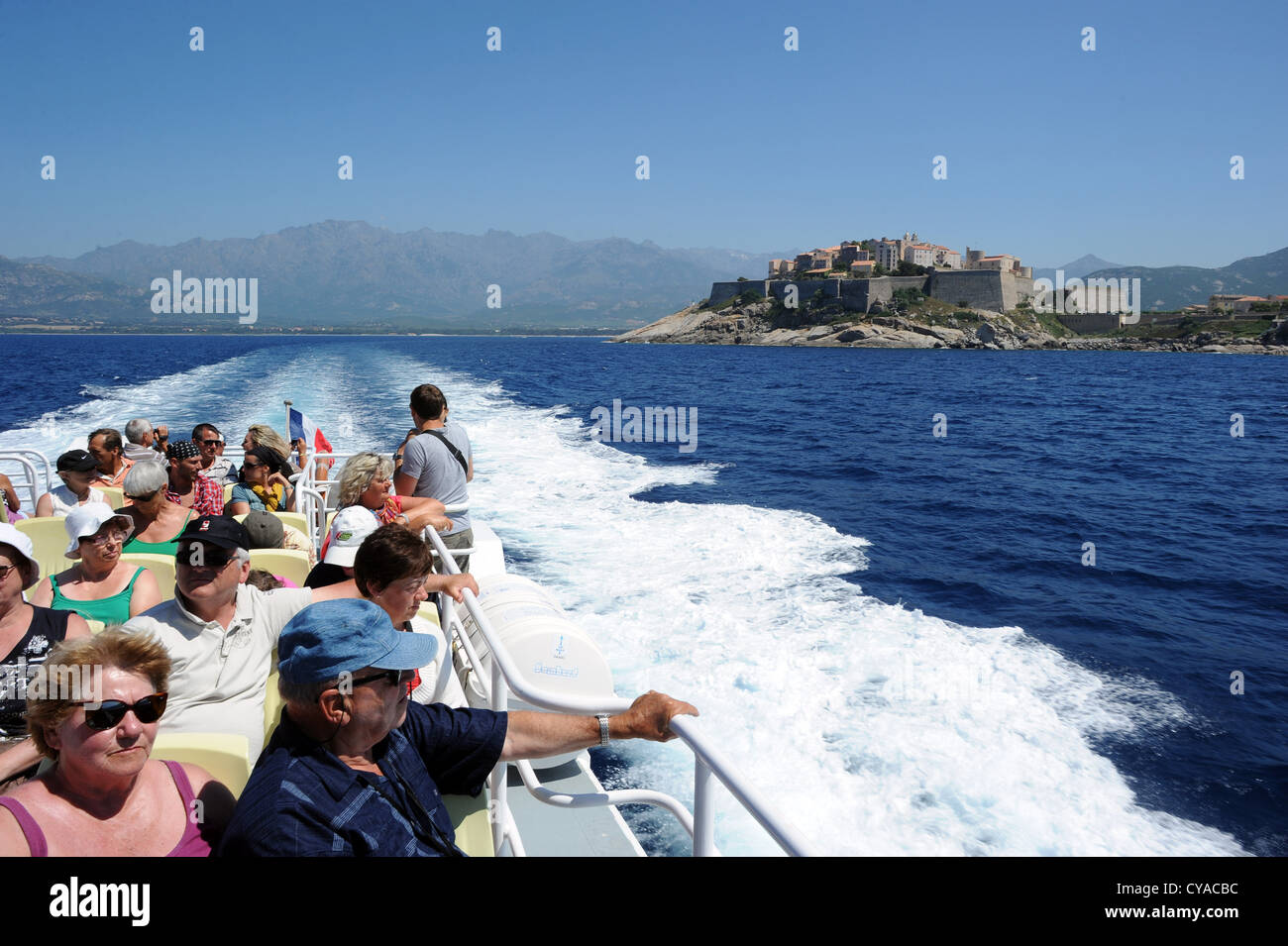 Touristen auf einem Ausflugsboot verlassen die Stadt Calvi Überschrift Scandola Natur behalten in Korsika, Frankreich. Stockfoto