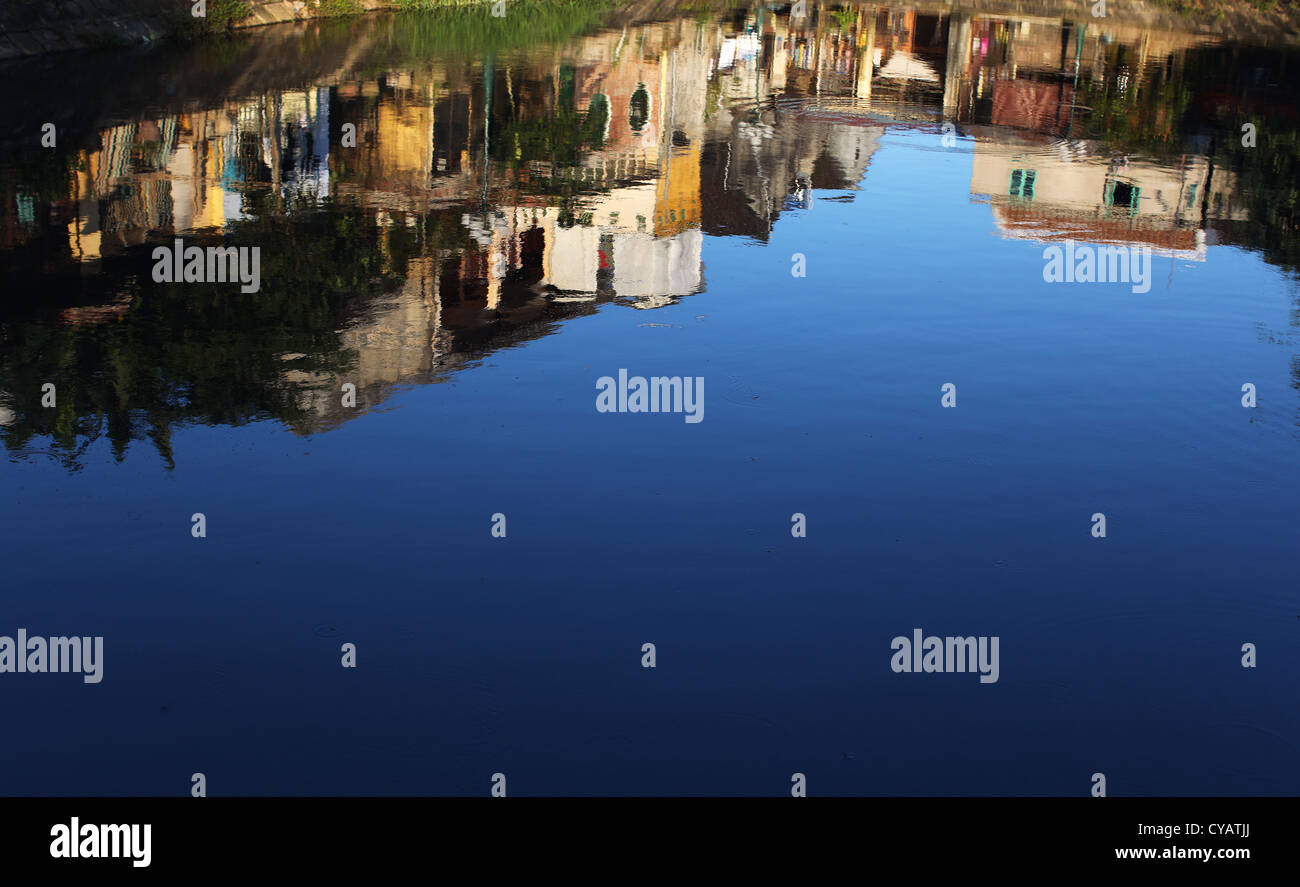 Spiegelung im Wasser eines Teiches, Häuser im Dorf Stockfoto
