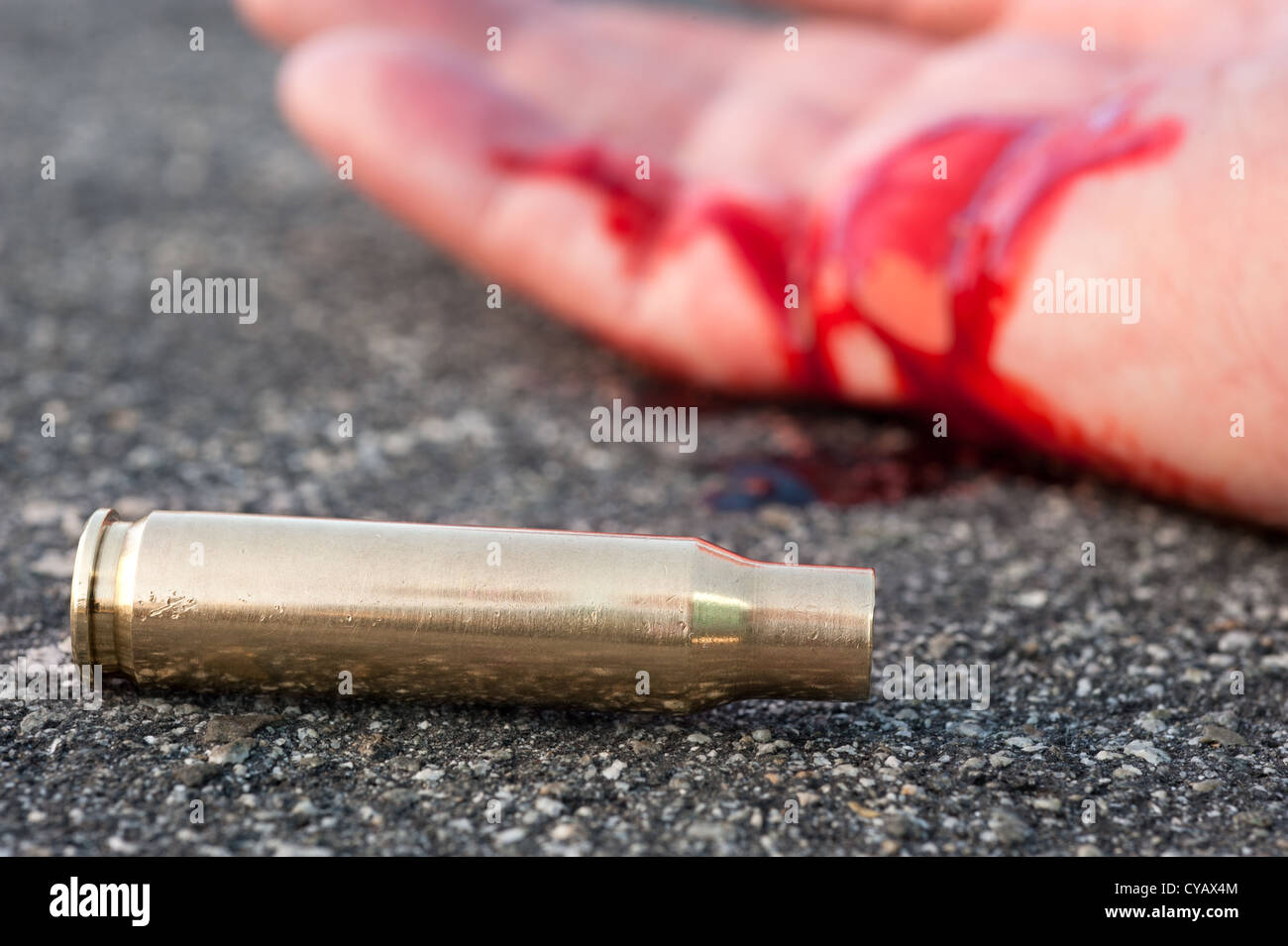 Ein Mann erschossen in den Straßen mit dem Aufzählungszeichen Gehäuse neben einer blutigen Hand zu legen. Stockfoto