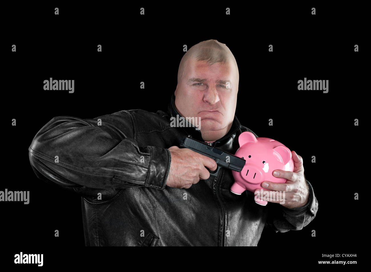 Ein maskierter Dieb droht, ein Sparschwein zu schießen, wie er es bei einer schlechten Wirtschaft stiehlt. Stockfoto