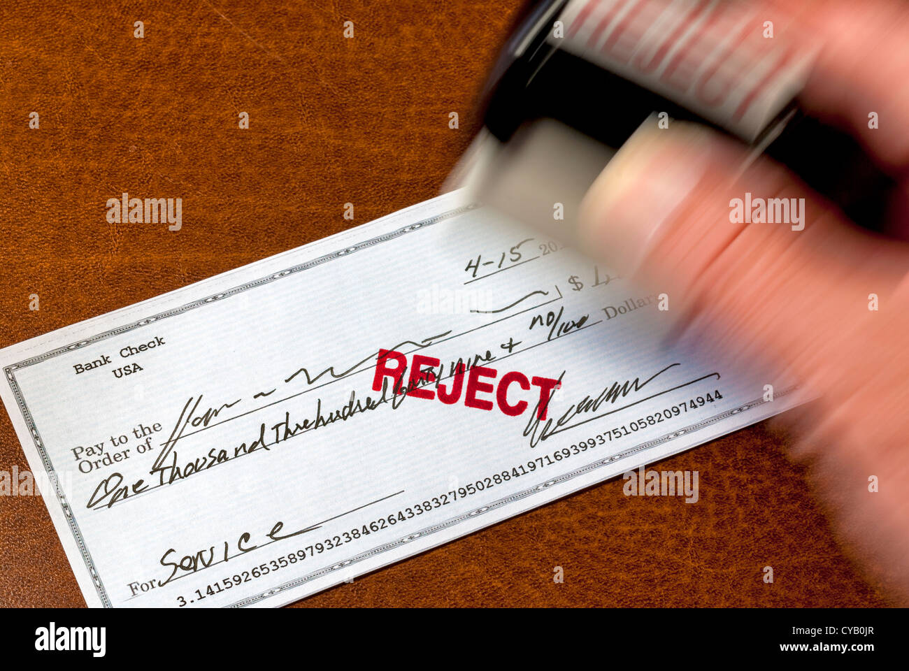 Eine Briefmarke wird verwendet, um einen persönlichen Scheck ablehnen zu markieren Stockfoto