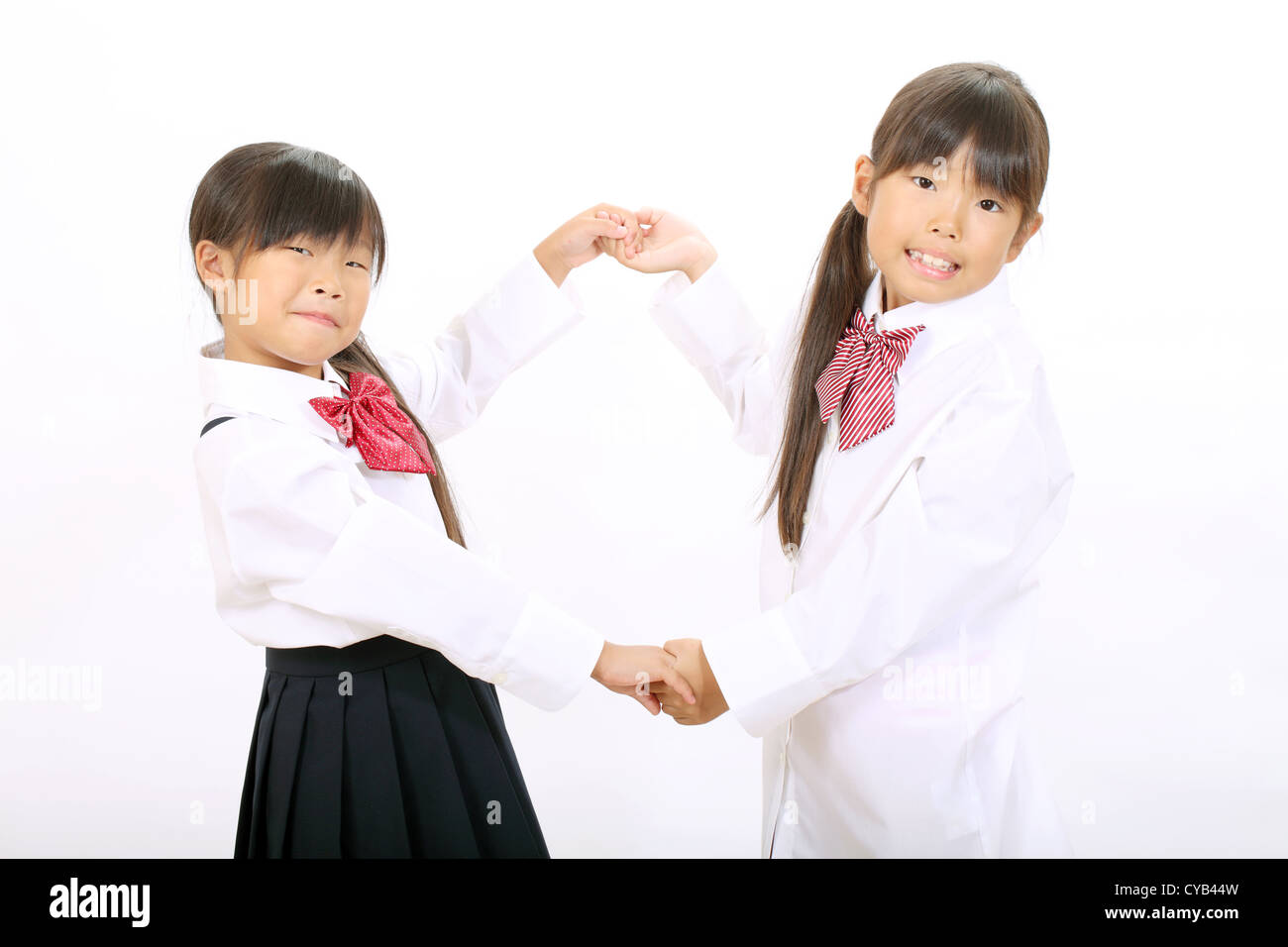 Zwei kleine asiatische Schulmädchen isoliert auf weißem Hintergrund Stockfoto