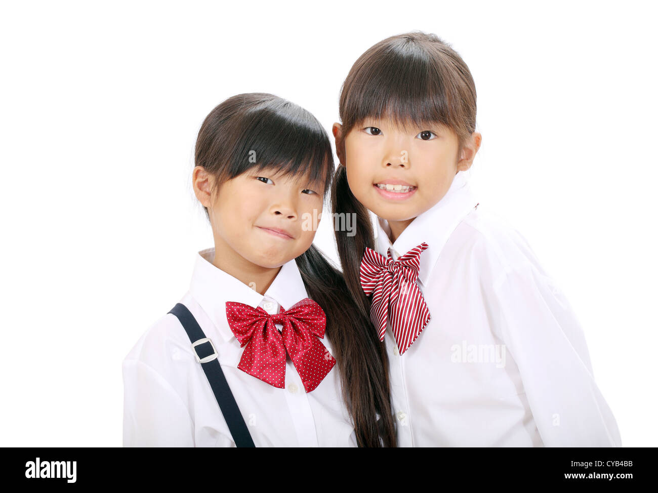 Zwei kleine asiatische Schulmädchen isoliert auf weißem Hintergrund Stockfoto