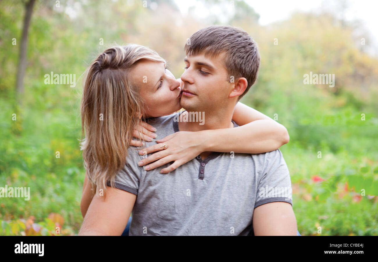 Einen Kerl küssen Mädchen auf die Wange. Paar in der Liebe im freien Stockfoto