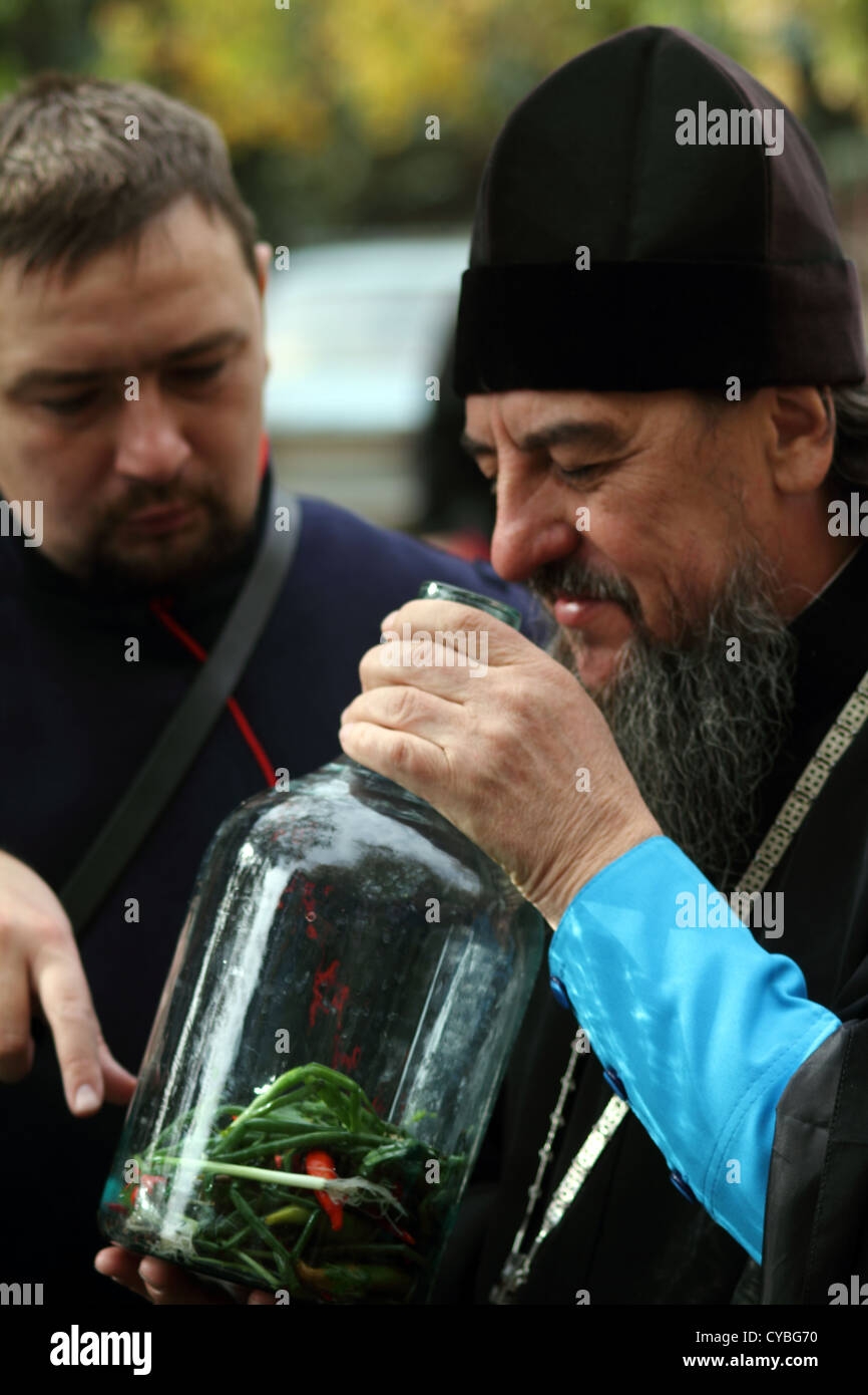 Don Cossack erzählt orthodoxe Priester über alten Kochen Utensil Wodka Infusionen Stockfoto