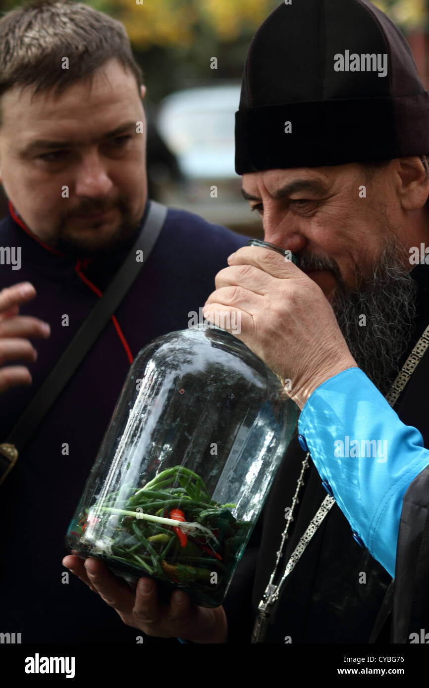 Don Cossack erzählt orthodoxe Priester über alten Kochen Utensil Wodka Infusionen Stockfoto