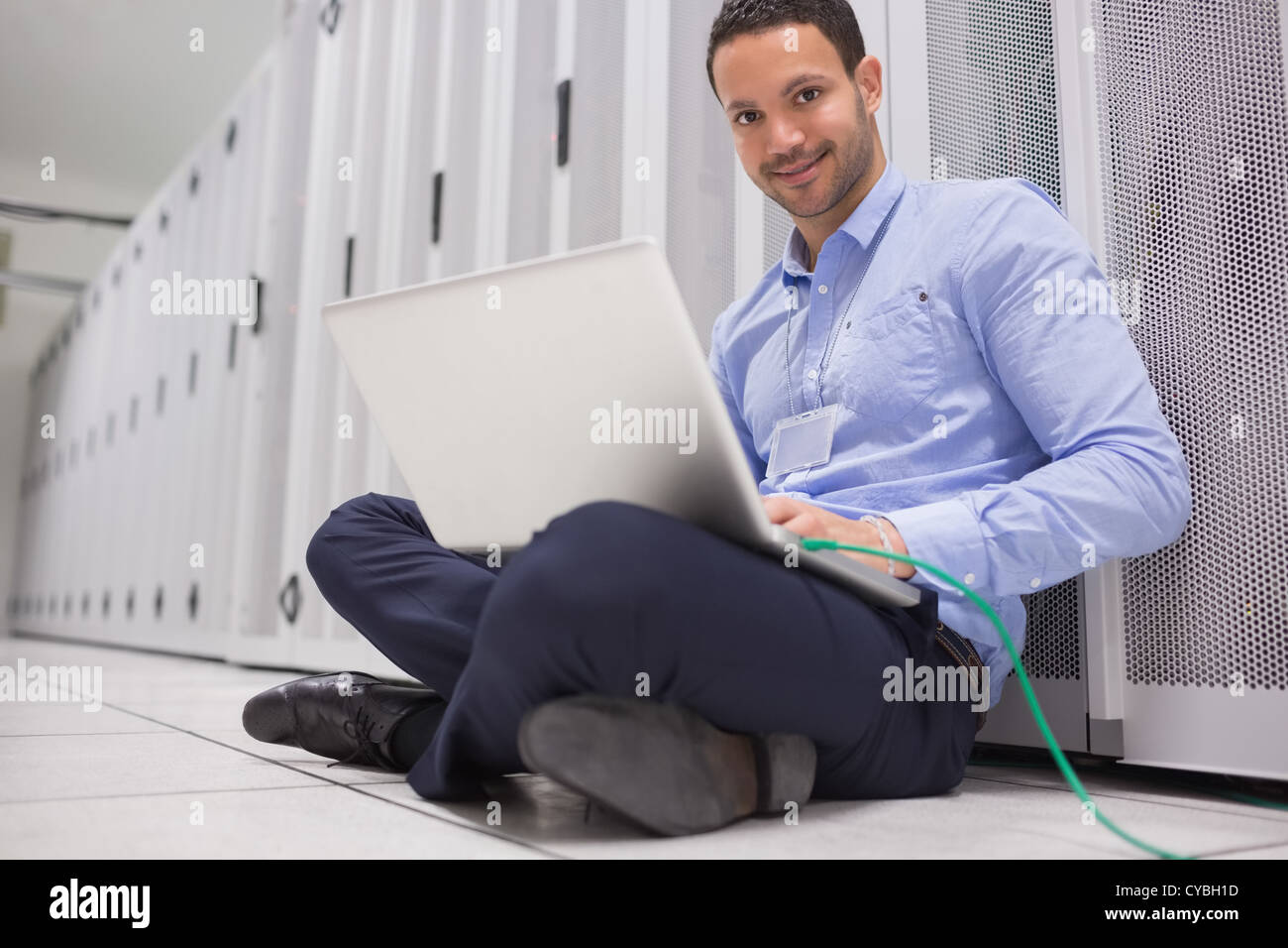 Mann arbeitet am Laptop angeschlossen, um server Stockfoto