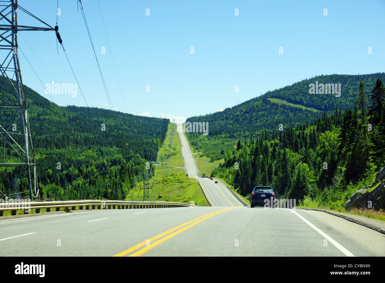 Bergstraße in schwarz-Fichte boreal Forest of Canada mit elektrischen Pilons in der Nähe von Parc des Laurentides, Quebec. Stockfoto