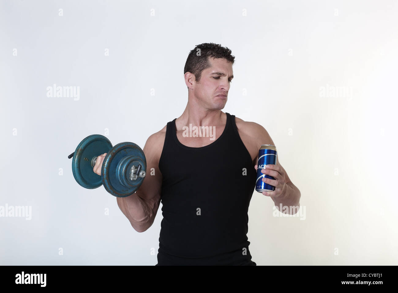 nicht sicher, ob er sollte einen Schluck Bier oder mit seiner Arbeit weitermachen, männlichen bodybuilder Stockfoto