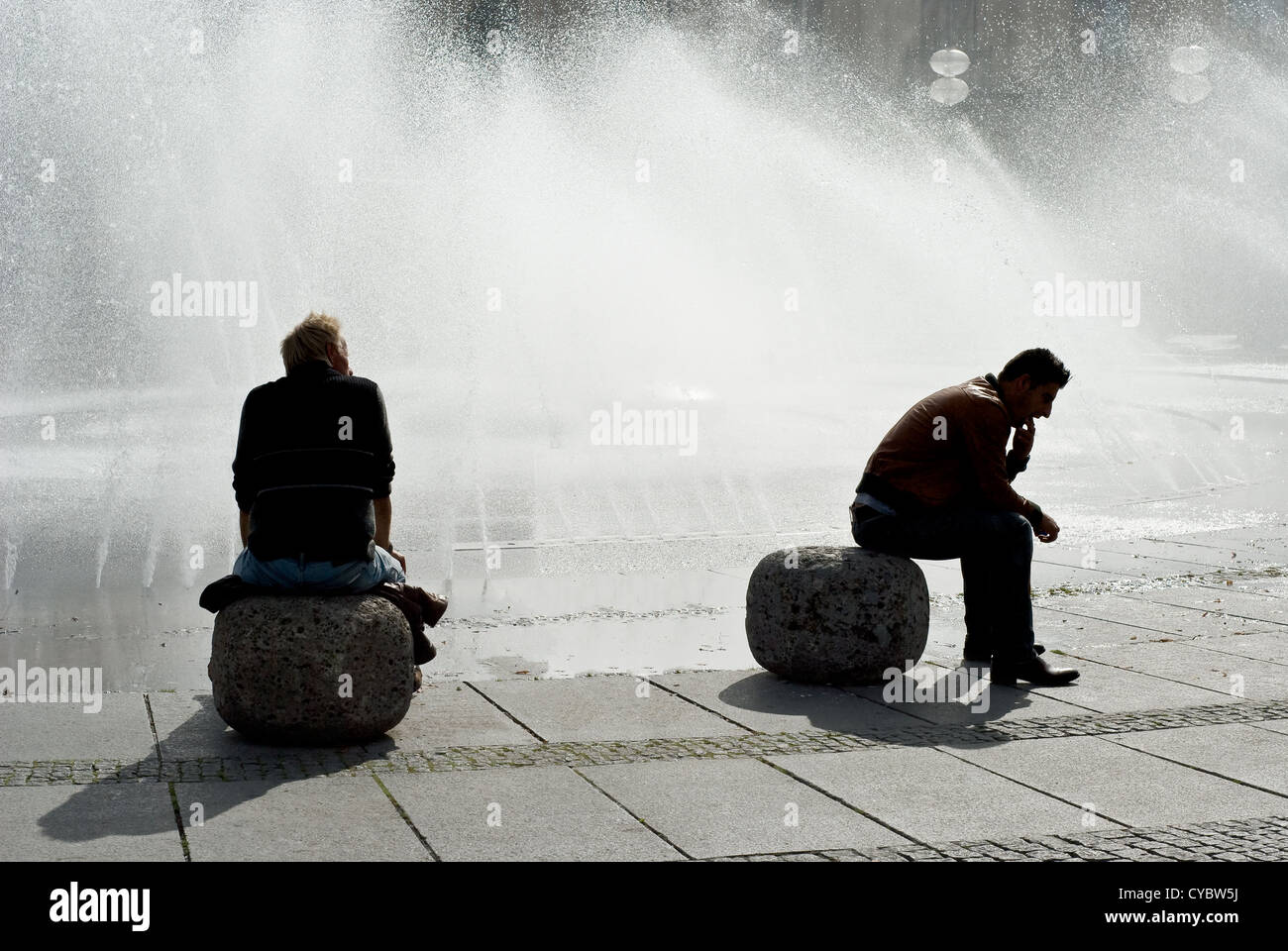 Silhouette von zwei Personen am Karstor Brunnen in München Stockfoto