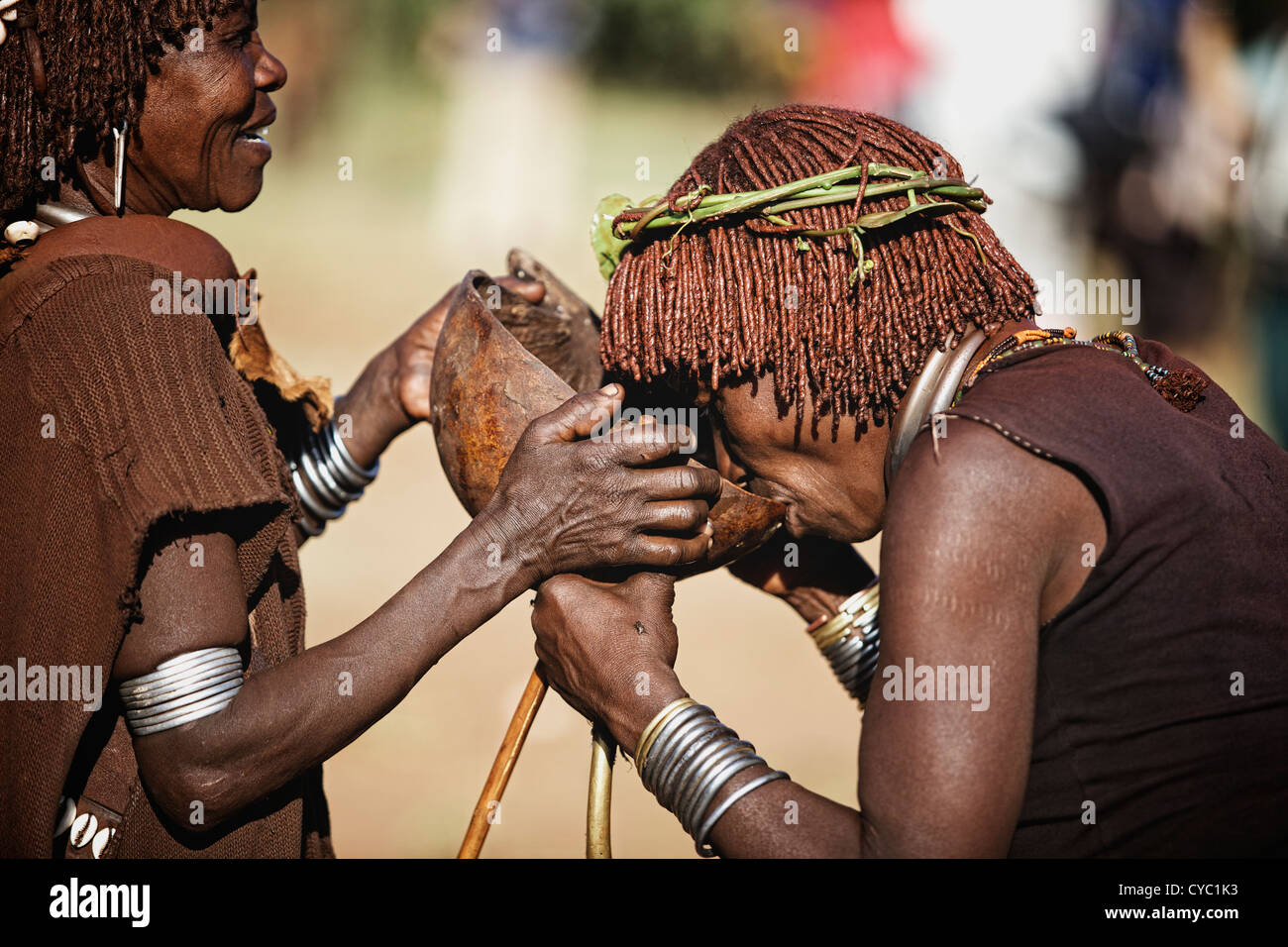 Hamar Frauen teilen Getränke während Bull Jumping Zeremonie. Stockfoto