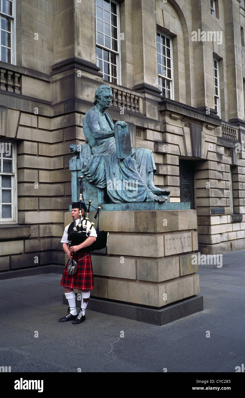 Kaukasischen Mann spielt Dudelsack von Hume Statue außerhalb der High Court of Justiciary, Lawnmarket, Royal Mile in Edinburgh, Schottland Stockfoto