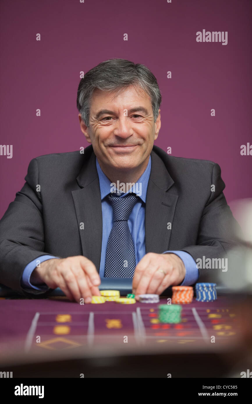 Lächelnder Mann Roulette in einem Casino spielen Stockfoto