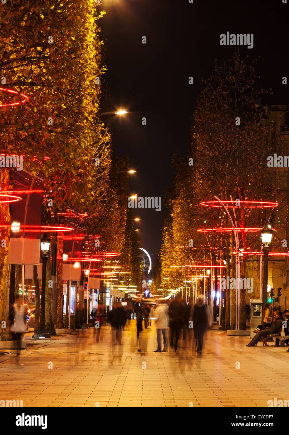 Nacht verschwommenes Bild von Menschen zu Fuß auf dem berühmten Boulevard Champs-Elysees in Paris während der Winterferien. Stockfoto