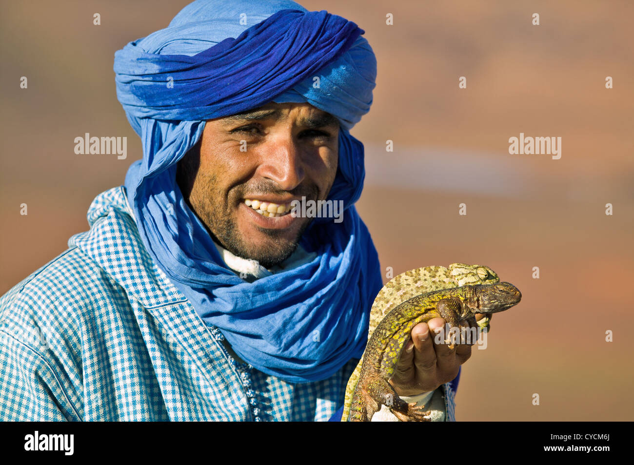 BERBER MANN MAROKKO MIT WÜSTE CHAMÄLEON UND AGAMA LIZARD DIE TIERE FÜR DEN VERKAUF SIND, gegessen zu werden. Stockfoto