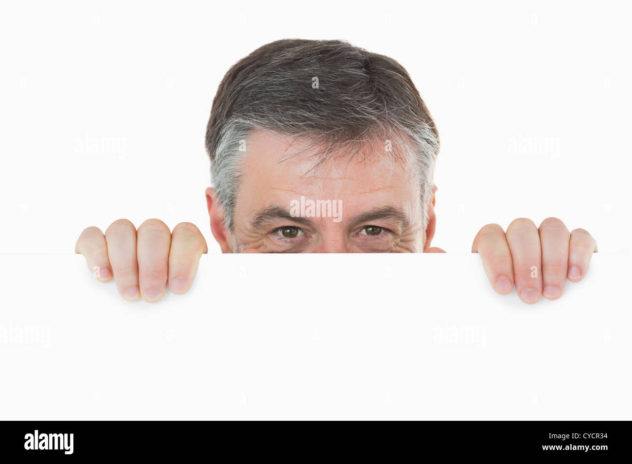 Man versteckt sich hinter weißen Tafel Stockfoto