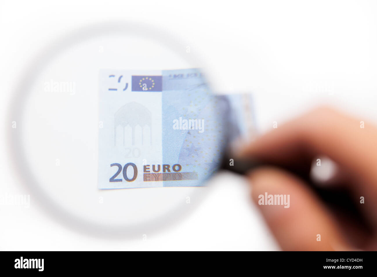 Hand mit Lupe auf Euro-Schein Stockfoto