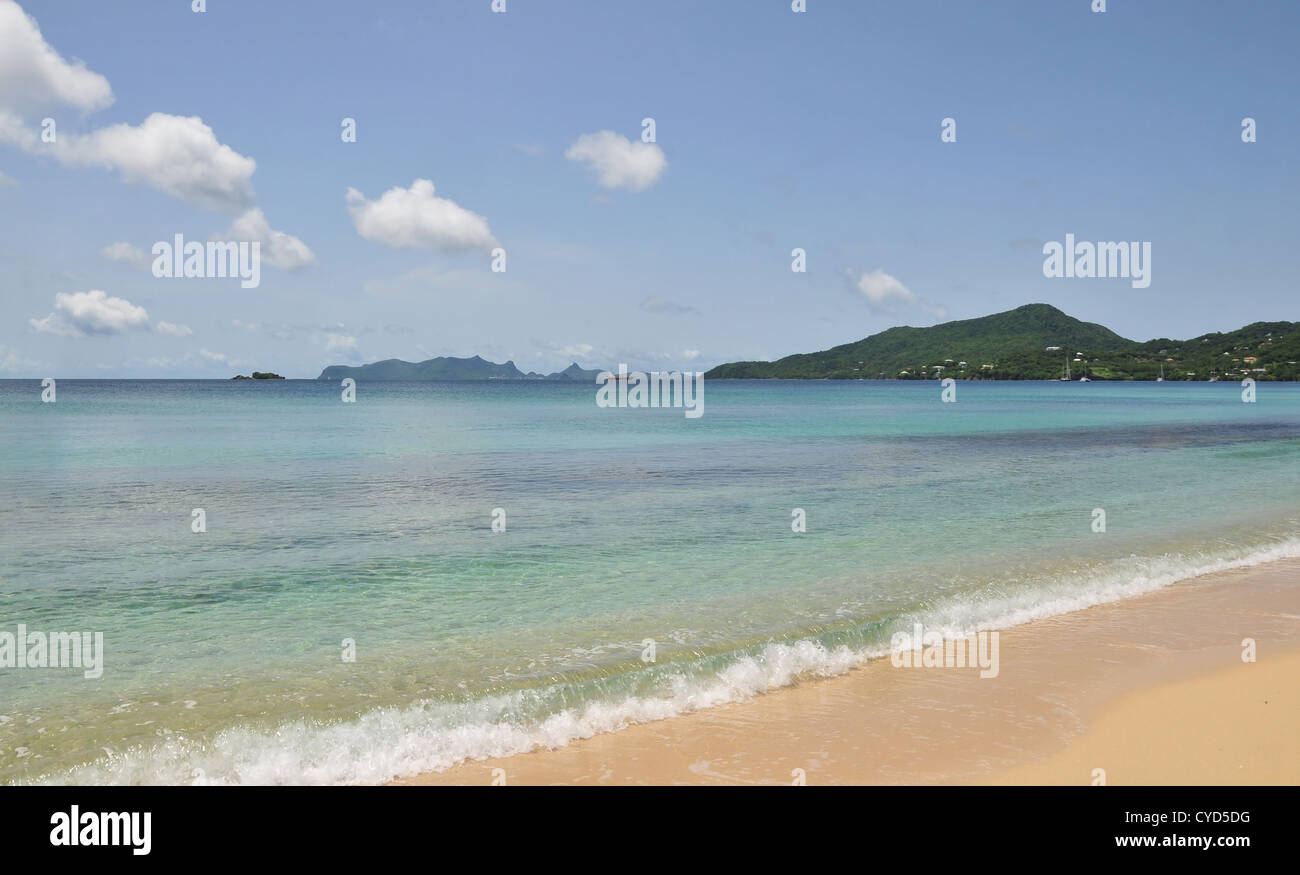 Blauer Himmel weiße Wolken Blick auf Union Island, Sand, smaragdgrüne Meer, grüne Hügel Häuser, Strand Hillsborough, Carriacou, West Indies Stockfoto