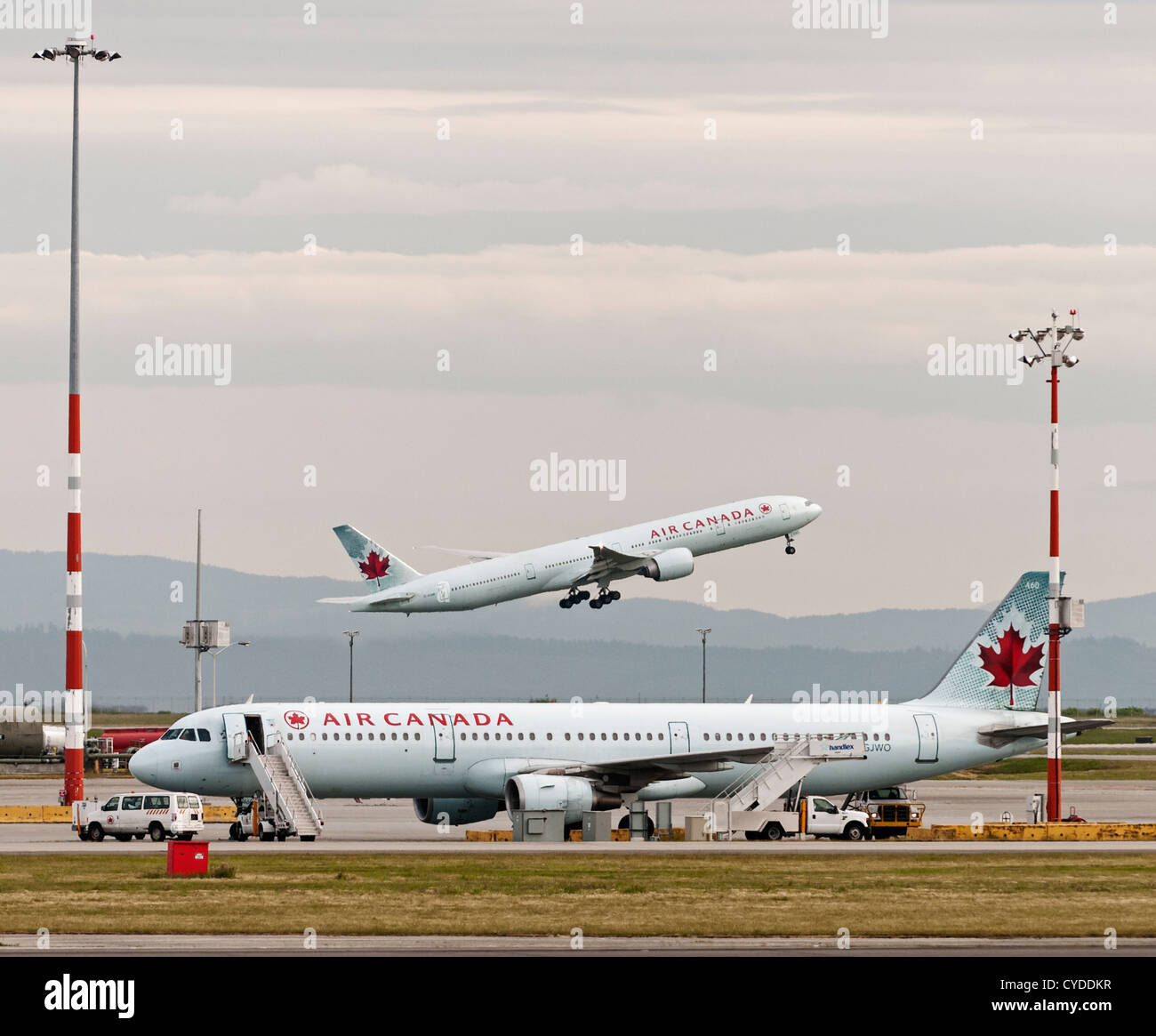 Air Canada Jetliner in Vancouver International Airport. Boeing 777-300ER C-FIUR nimmt aus Airbus A321-200 C-GJWO geparkt Stockfoto