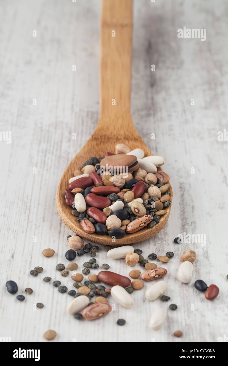 Sortiment von verschiedenen rohen Hülsenfrüchten mit einem Holzlöffel gemischt Stockfoto
