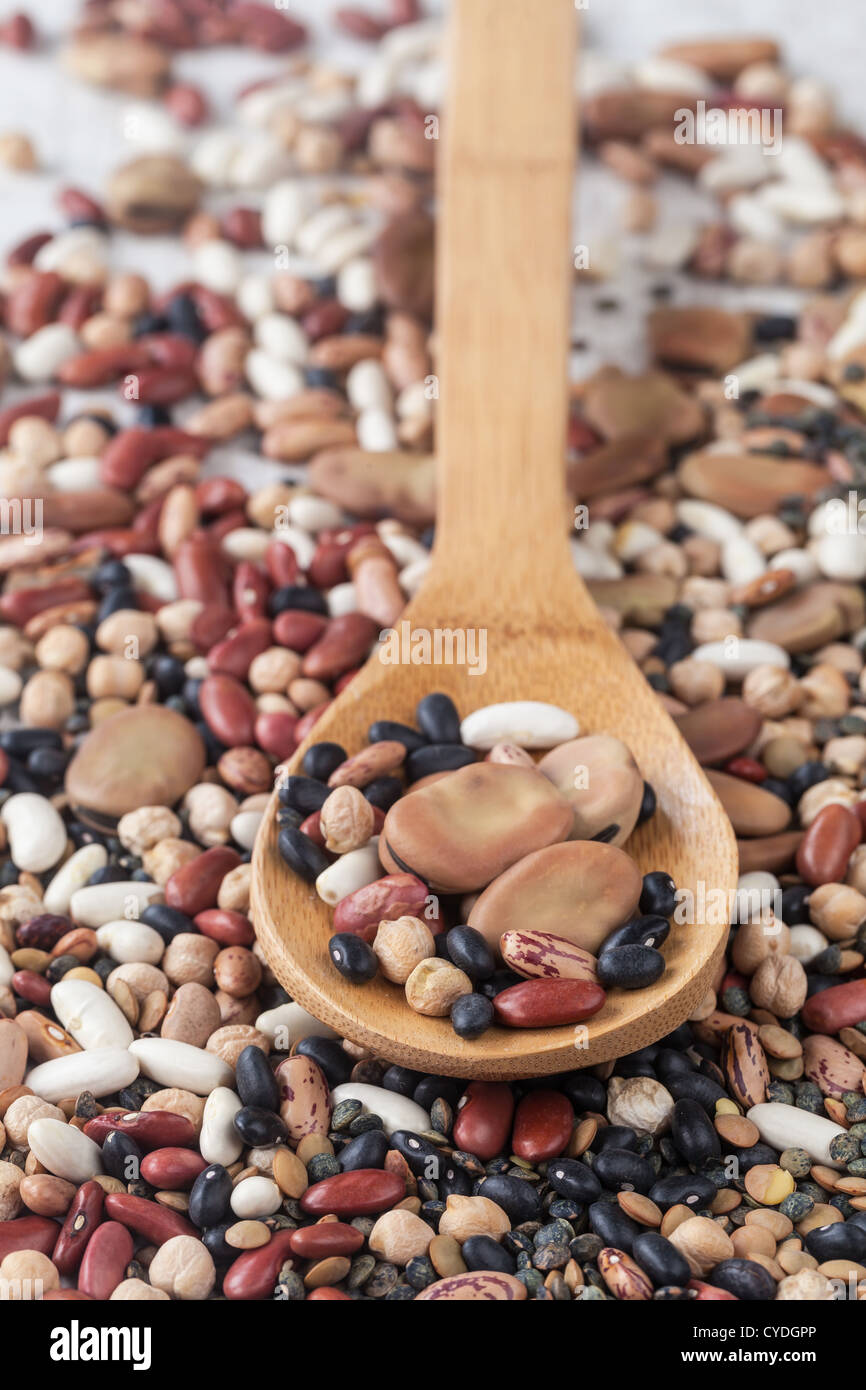Sortiment von verschiedenen rohen Hülsenfrüchten mit einem Holzlöffel gemischt Stockfoto