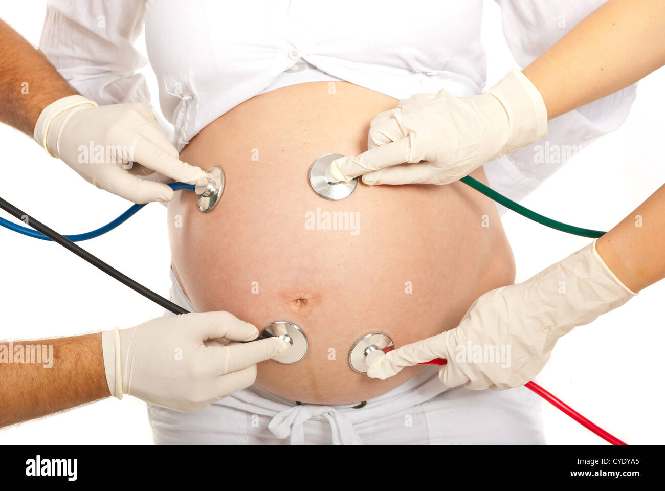 Viele Stethoskope untersuchen schwangeren Bauch isoliert auf weißem Hintergrund Stockfoto