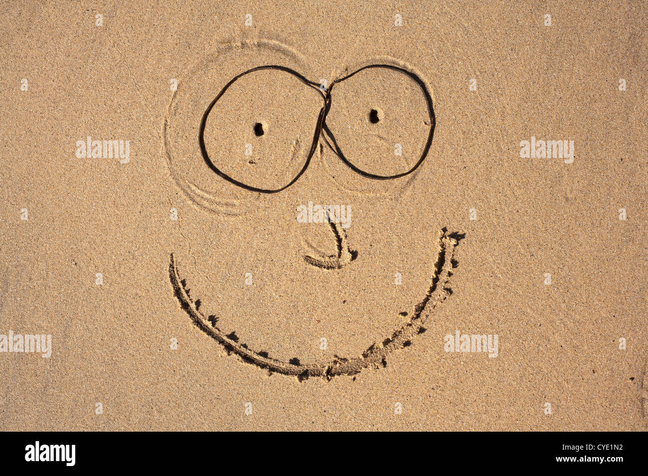 Smiley-Gesicht auf einem Cornish Strand mit Algen Brille in Sand gezeichnet Stockfoto