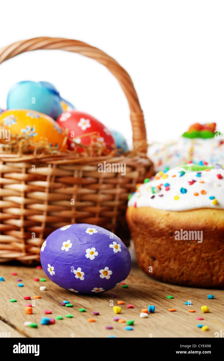 Osterdekoration - Eiern, Kuchen und Korb auf der Tischplatte Stockfoto
