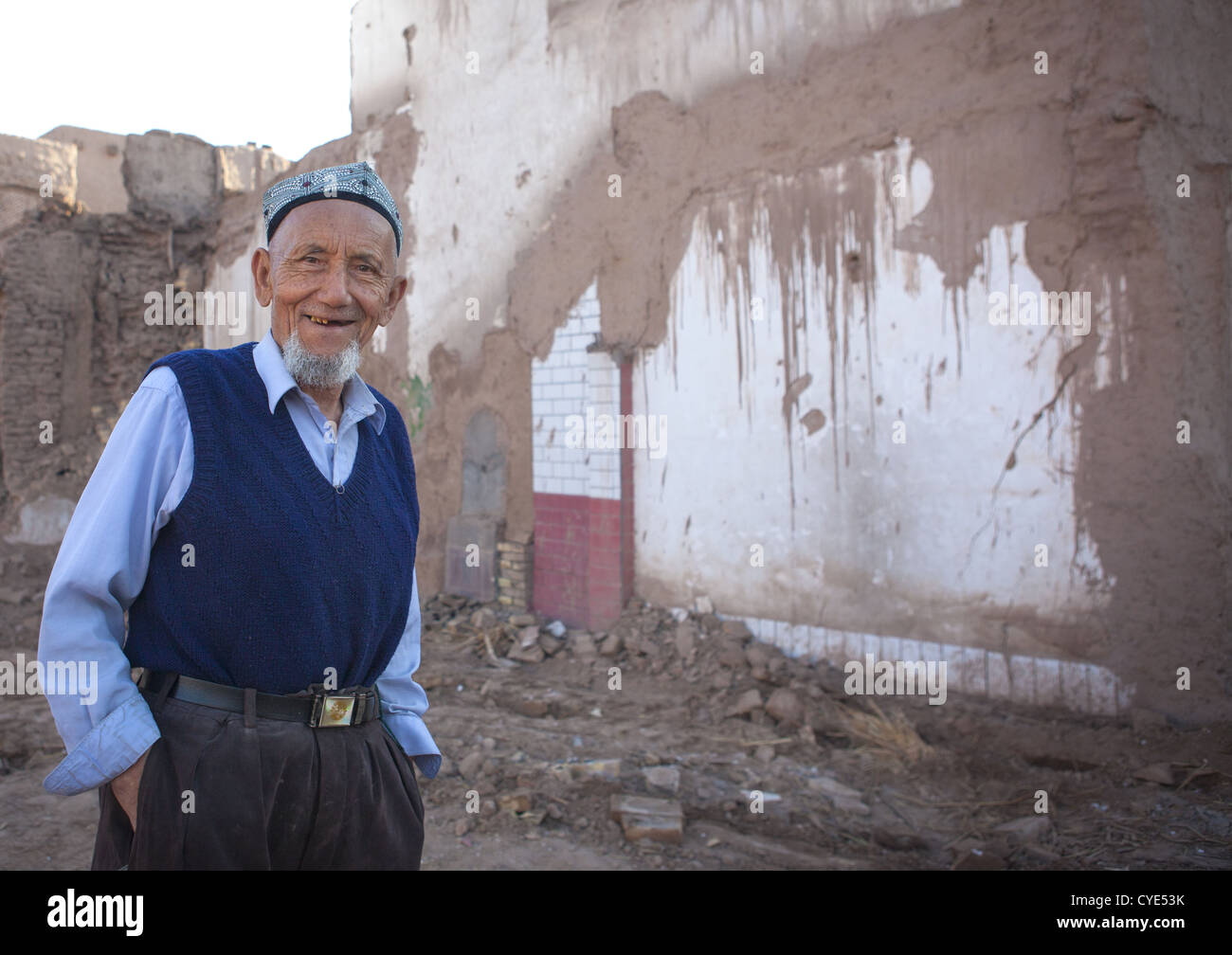 Uyghur Mann vor abgerissenen Haus, Altstadt von Kashgar, Xinjiang Uyghur autonome Region, China Stockfoto