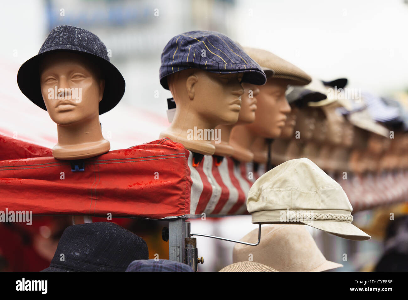 Eine ist aus der Gruppe, Plastikmodell Köpfe mit den Hüten auf dem freien Markt. Stockfoto
