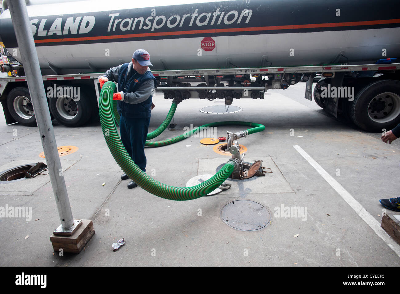Ein Kraftstoff-LKW-Betreiber liefert Benzin an einer Tankstelle Hess in der Clinton-Viertel von Manhattan in New York City Stockfoto